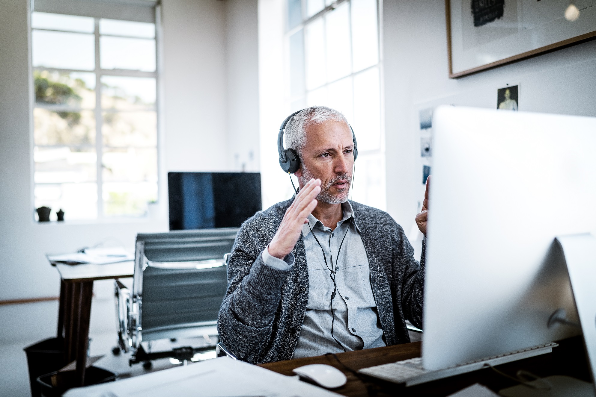 Confident businessman video conferencing at desk online training